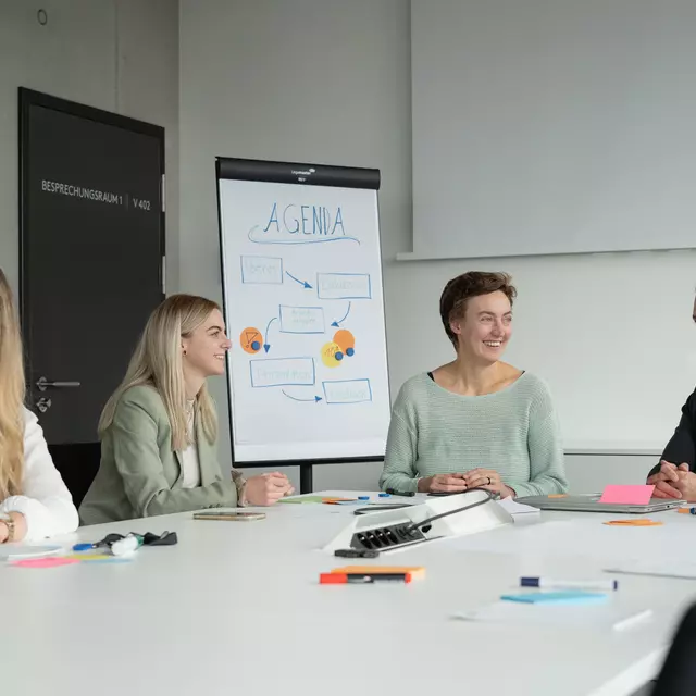 Mitarbeiterinnen und Mitarbeiter der OTH Regensburg sitzen im Meetingraum