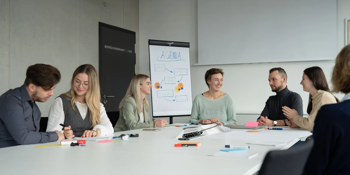 Mitarbeiterinnen und Mitarbeiter der OTH Regensburg sitzen im Meetingraum