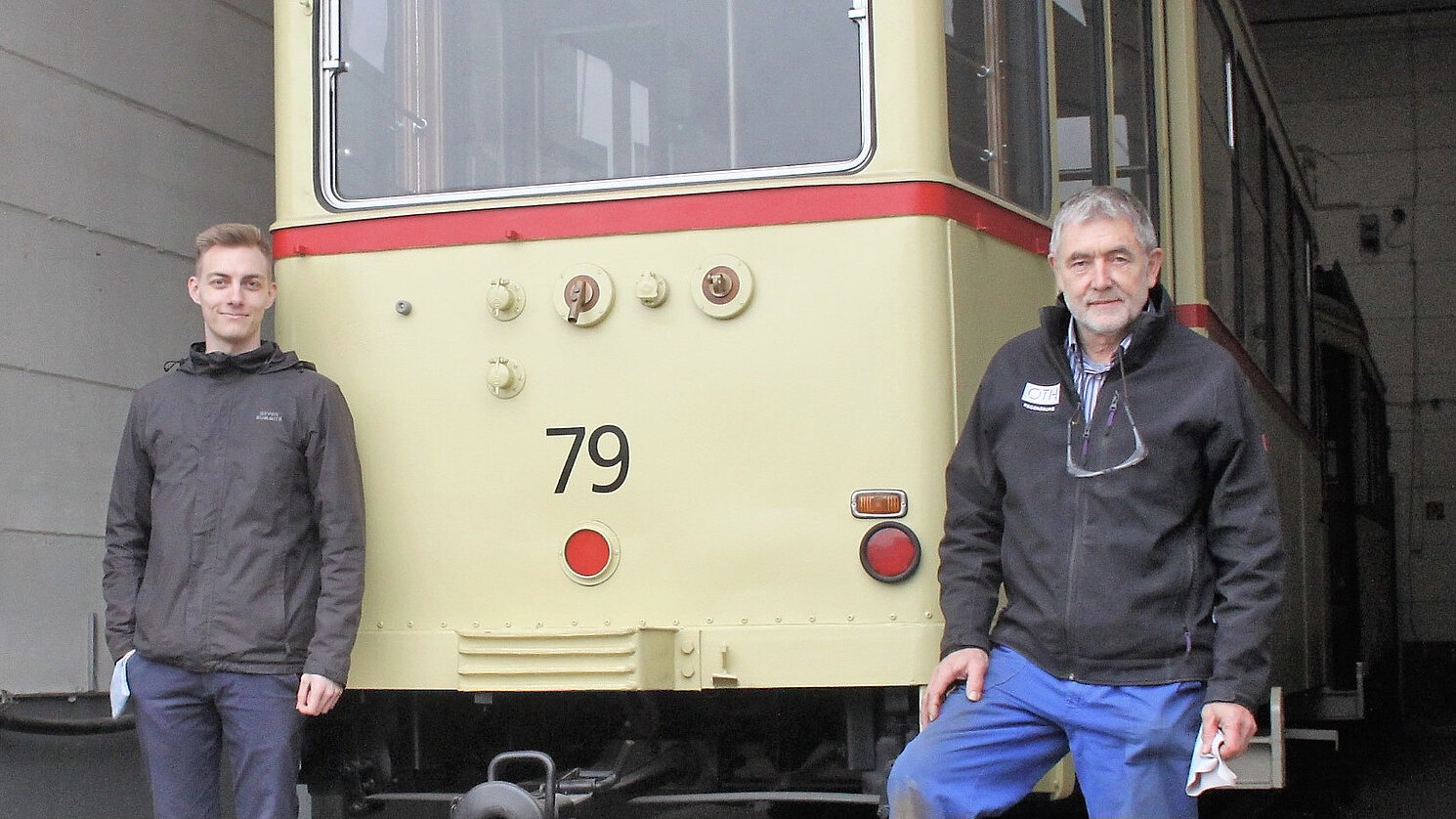 Von links: Bachelorand Jakob Hiltl und Labormeister Walter Stelzl von der OTH Regensburg vor dem restaurierten Beiwagen der Historischen Regensburger Straßenbahn. Im Hintergrund steht der Triebwagen.