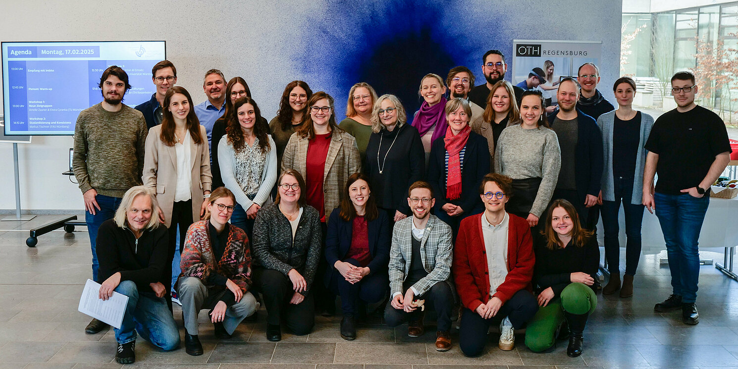 Gruppenfoto vor einer Wand mit blauem Kunstwerk