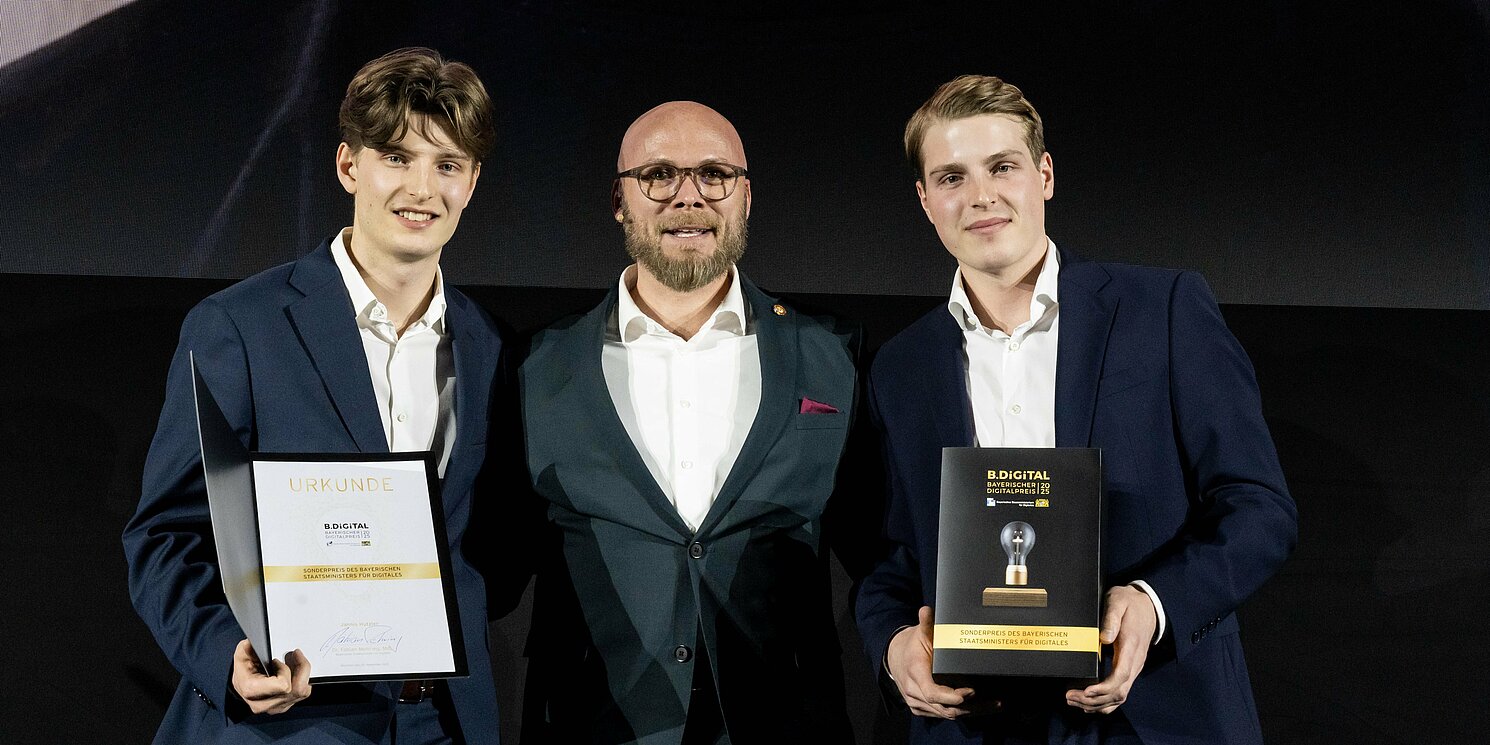 Digitalminister Dr. Fabian Mehring (Mitte) überreichte den Sonderpreis B.DiGiTAL an Moritz (links) und Jannis Hutzler für ihren Unternehmergeist mit gesellschaftlicher Verantwortung. Foto: StMD/Kaspar Kozub