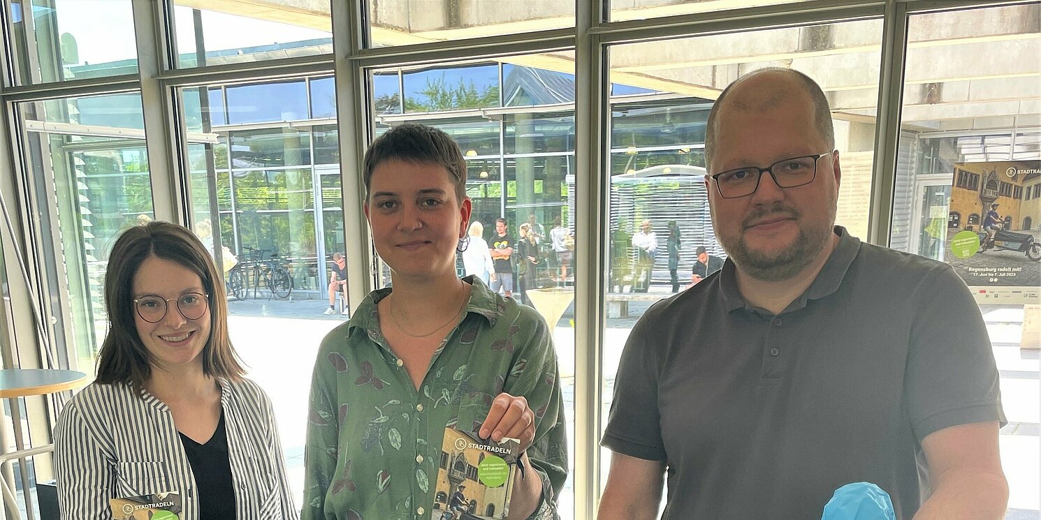 Karoline Raab (v.l.) und Sophia Götz von der Firma Valentum Kommunikation sowie Jürgen Bachl, Team-Kapitän der OTH Regensburg, verteilten vor der Mensa Sattelschutz, Fahrradreparatursets und Flyer zur Aktion Stadtradeln. Foto: Simone Grebler/OTH Regensburg