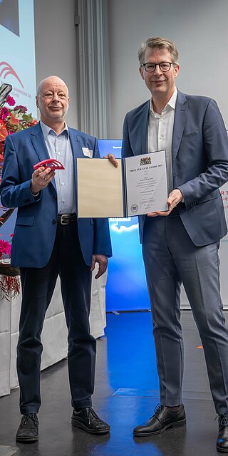 Wissenschaftsminister Markus Blume (rechts) überreicht Prof. Dr. Martin Pohl den „Preis für gute Lehre“. Foto: Axel König/StMWK