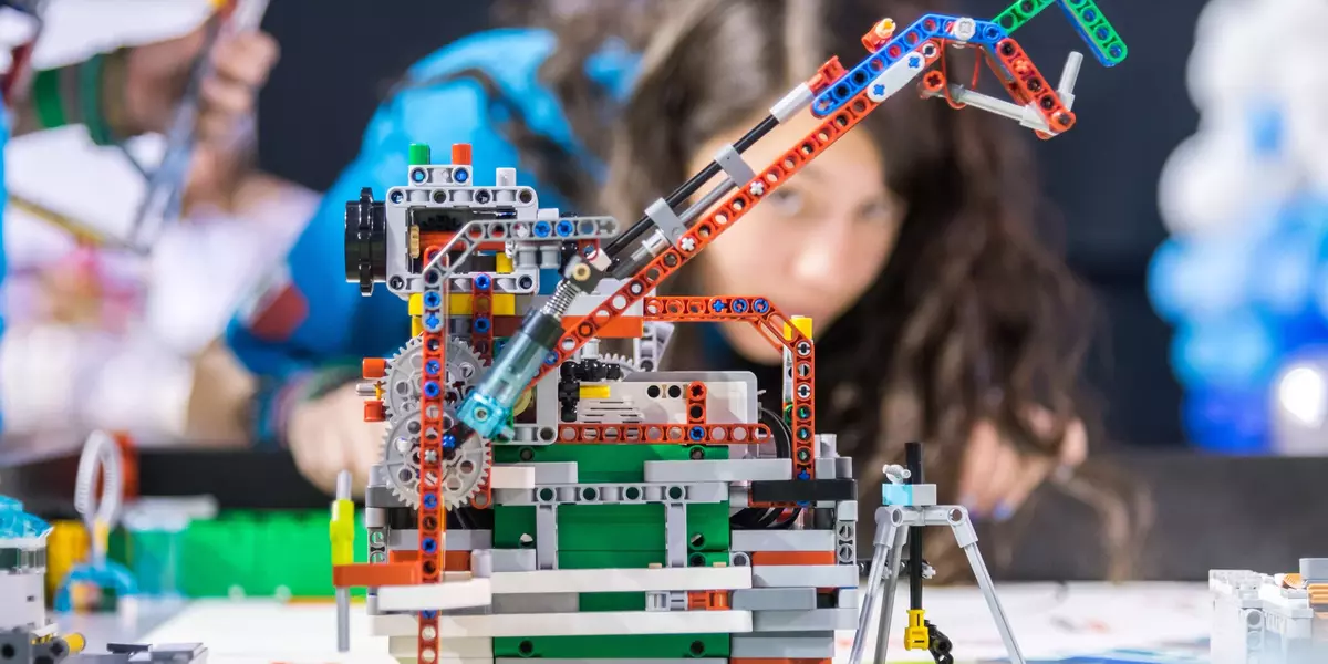 Foto Lego Roboter mit Personen im Hintergrund