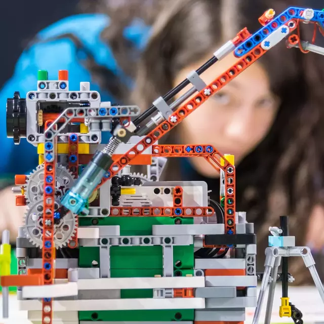 Foto Lego Roboter mit Personen im Hintergrund